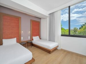 Two single beds with white linens and wooden red-framed headboards next to a large window at B&B Hotel Padova Methis