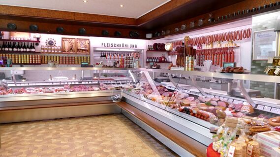 Verkaufsraum mit Theken voller Fleisch- und Wurstwaren sowie Regalen im Hotel & Metzgerei See, typisch f&uuml;r eine Metzgerei mit Fleischk&uuml;hlung.