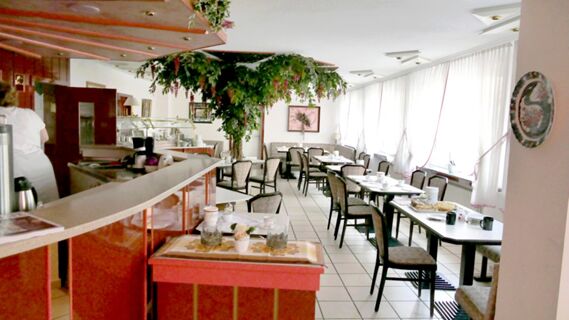Helles und einladendes Restaurant mit vielen Tischen und St&uuml;hlen sowie einem Pflanzenarrangement im Hotel & Metzgerei See.