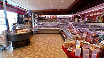 Interi&oslash;rbilde av slakterbutikken i Hotel & Metzgerei See med kj&oslash;ttdisker, p&oslash;lseprodukter og regionale spesialiteter p&aring; et lyst gulv.