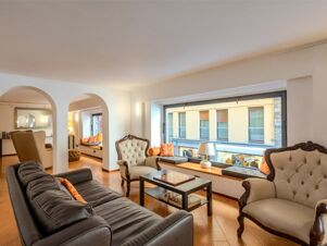 Living room with black leather sofa, two beige armchairs, a window seat, and a coffee table at B&B Hotel Firenze Pitti Palace al Ponte Vecchio