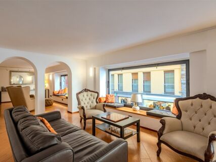 Living room with black leather sofa, two beige armchairs, a window seat, and a coffee table at B&B Hotel Firenze Pitti Palace al Ponte Vecchio