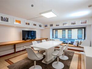 Meeting room with white table and chairs, wall-mounted TV, framed photos, and window seating at B&B Hotel Firenze Pitti Palace al Ponte Vecchio