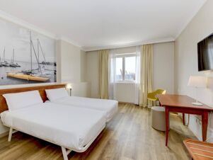 Two single beds with white linens in a hotel room at B&B Hotel Affi Lago di Garda with wooden floors and a desk