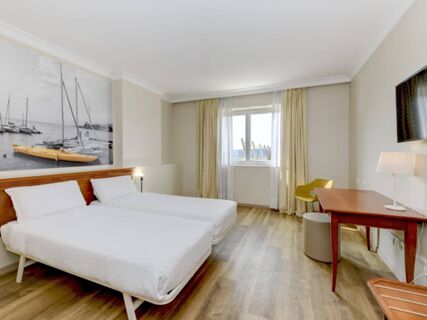 Two single beds with white linens in a hotel room at B&B Hotel Affi Lago di Garda with wooden floors and a desk