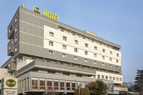Modern multi-story gray and white building with many windows and B&B Hotel Modena signs on top and near entrance