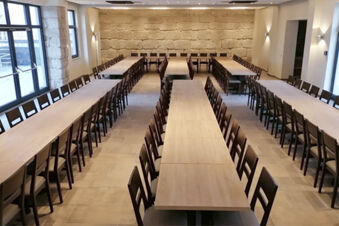 Velk&aacute;, světl&aacute; konferenčn&iacute; m&iacute;stnost s mnoha dřevěn&yacute;mi stoly a židlemi v hotelu Landgasthof Niebler, vhodn&aacute; pro poř&aacute;d&aacute;n&iacute; akc&iacute;.