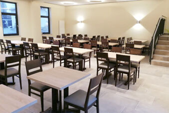 Modern&iacute;, světl&aacute; j&iacute;delna s dřevěn&yacute;mi stoly a židlemi v hotelu Landgasthof Niebler, ide&aacute;ln&iacute; pro skupiny a akce.