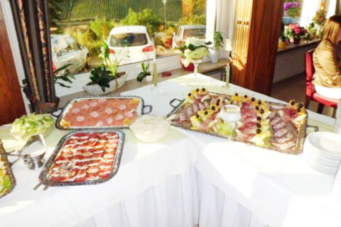 Buffet table with assorted cold cuts, salads, and appetizers set on a white tablecloth at Burg-Hotel Obermoschel