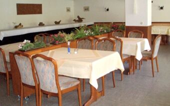 Dining area at Rheinhotel Zum Anker with tables covered in white cloths and wooden chairs arranged around them