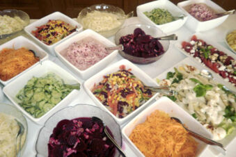 An assortment of various salads including shredded carrots, cucumber, beetroot, mixed vegetable, and creamy salads in bowls at Landgasthof Bieg