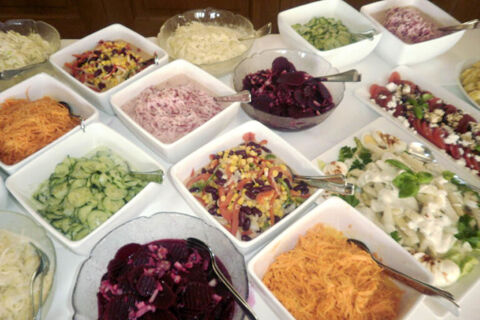 An assortment of various salads including shredded carrots, cucumber, beetroot, mixed vegetable, and creamy salads in bowls at Landgasthof Bieg