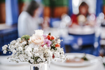 Bouquet of white baby&rsquo;s breath, pink roses, and other flowers in a silver vase at Landgasthof Restaurant Adler