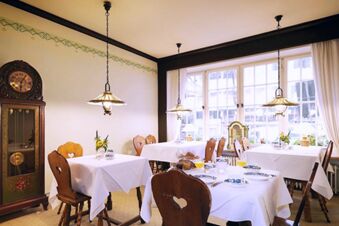 Alt N&uuml;rnberg 酒店內明亮舒適的餐廳，配備傳統木質傢俱和裝飾元素。