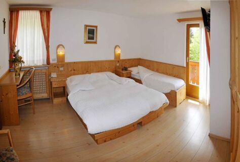 &Uacute;tuln&yacute; hotelov&yacute; pokoj se dvěma lůžky, dřevěn&yacute;m n&aacute;bytkem a balkonem v hotelu Albergo Nido Verde, světl&yacute; a př&iacute;jemn&yacute;.