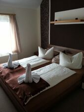 Gem&uuml;tliches Doppelzimmer mit Fenster und dekorativen Handtuchschw&auml;nen im Hotel-Pension Loreley, sauber und einladend gestaltet.