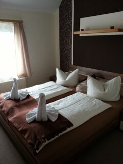 Gem&uuml;tliches Doppelzimmer mit Fenster und dekorativen Handtuchschw&auml;nen im Hotel-Pension Loreley, sauber und einladend gestaltet.