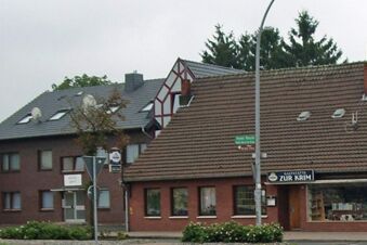 Fassade des Hotels garni Zur Krim mit traditionellem Ziegeldach und angrenzender Gastst&auml;tte in einer ruhigen Umgebung.