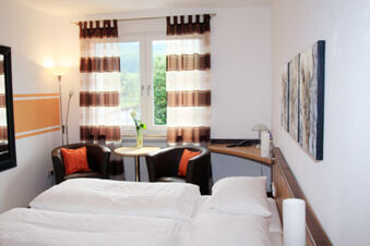 Hotel room at Rh&ouml;ngasthof Zur Linde & Ferien-Appartements Rh&ouml;nsicht with twin beds, two chairs, a table, and window with curtains