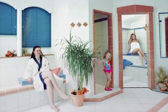 Two women and a child relaxing in a tiled spa area at Rh&ouml;ngasthof Zur Linde & Ferien-Appartements Rh&ouml;nsicht