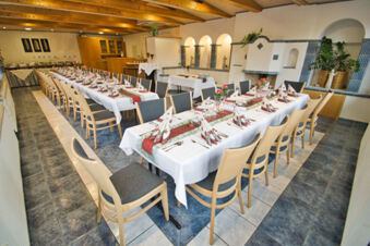 Dining room with long tables set with white tablecloths, folded napkins, and flowers at Rh&ouml;ngasthof Zur Linde & Ferien-Appartements Rh&ouml;nsicht