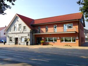 Ansicht der Fassade von K&ouml;hncke's Hotel mit rotem Ziegeldach, zweist&ouml;ckigem Geb&auml;ude und klarer Tageslichtszene