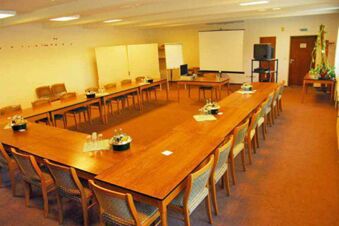 Konferenzraum im Landhotel Helms mit U-f&ouml;rmig angeordneten Tischen, St&uuml;hlen und Pr&auml;sentationsmaterialien f&uuml;r Meetings.