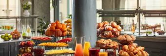 Buffet mit frischem Obst, Backwaren und S&auml;ften im hellen Fr&uuml;hst&uuml;cksraum des NH Collection Hotel Heidelberg in modernem Ambiente.