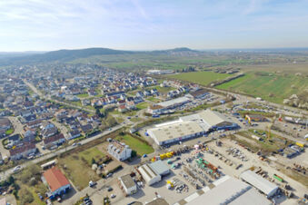 Luftaufnahme einer Stadt mit Wohnh&auml;usern und Industrieanlagen, Umgebung von Hotel Kick mit l&auml;ndlichem Panorama