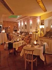 Dining area with wooden chairs and tables set with napkins and wine glasses in Marktplatzhotel u. Bistrorant Tafelspitz