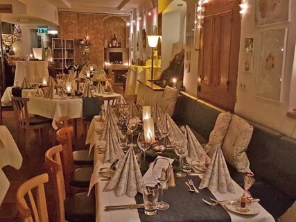 Gem&uuml;tlich dekorierter Restaurantbereich mit festlich gedeckten Tischen und Kerzenlicht im Marktplatzhotel u. Bistrorant Tafelspitz.