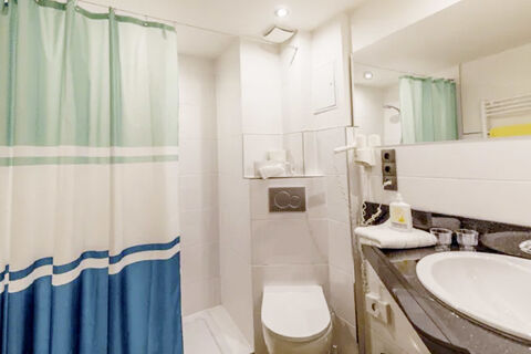 Modernes Badezimmer mit Duschvorhang, WC, Waschbecken und Haartrockner im Marktplatzhotel u. Bistrorant Tafelspitz.