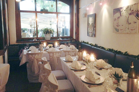 Dining area at Marktplatzhotel u. Bistrorant Tafelspitz with white covered chairs, folded napkins, candles, and table settings
