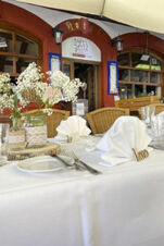 Outdoor dining table with white cloth, folded napkins, flowers, and cutlery at Marktplatzhotel u. Bistrorant Tafelspitz