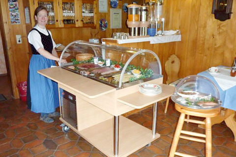 Gastgeberin serviert ein Buffet mit kalten Speisen und Getr&auml;nken im rustikalen Restaurant vom Bauernhof W&auml;ldebauernhof.