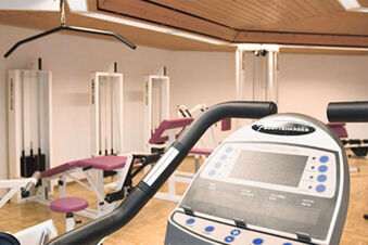 Moderner Fitnessraum mit Trainingsger&auml;ten und Ergometer im Hotel Landgut Burg f&uuml;r sportliche Aktivit&auml;ten der G&auml;ste
