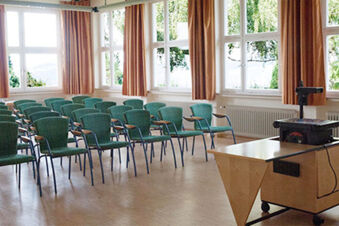 Konferenzraum mit gr&uuml;nen St&uuml;hlen und gro&szlig;en Fenstern bei Hotel Landgut Burg, ideal f&uuml;r Tagungen oder Seminare.
