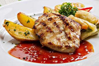 Gegrilltes Fleisch mit Kartoffelspalten, Fr&uuml;hlingsrollen und frischer Sauce auf wei&szlig;em Teller serviert im Landhotel-Restaurant Mei&szlig;nerhof.