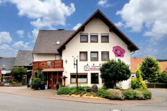 Das Landhotel-Restaurant Mei&szlig;nerhof zeigt seine traditionelle wei&szlig;e Fassade mit braunen Fenstern und einem gro&szlig;en Blumenmotiv an der Au&szlig;enwand.