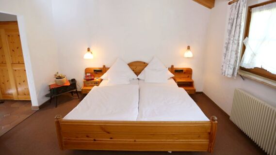 Schlicht eingerichtetes Doppelzimmer mit Holzm&ouml;beln und Fenster, gem&uuml;tlich und funktional im Hotel Lochm&uuml;hle GmbH.