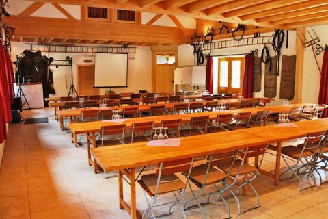 Gro&szlig;er Seminarraum mit Holztischen und St&uuml;hlen, Leinwand und Flipcharts im Hotel Lochm&uuml;hle GmbH, gem&uuml;tlich und rustikal eingerichtet.