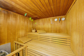 Innenaufnahme einer klassischen Sauna mit Holzb&auml;nken und Thermometern bei Meyenburg & Gerds H&ouml;ft Appartements am Wattenmeer.