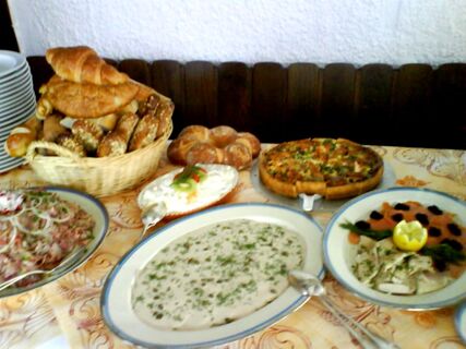 Buffet mit verschiedenen Brotsorten, Pizza und kalten Gerichten auf einem Tisch im Hotel-Restaurant zum Wilden Mann.