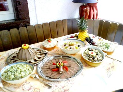 Tisch mit verschiedenen kalten Speisen und Salaten in einem rustikalen Raum im Hotel-Restaurant zum Wilden Mann, dekorativ angerichtet.