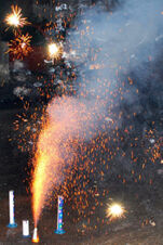 Sparklers and ground fireworks emit bright orange sparks and smoke on a street at Gasthof Lamm Hotel und Restaurant