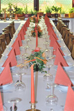 在 Gasthof Lamm Hotel and Restaurant 明亮的房間中，擺放著紅色餐巾、蠟燭和鮮花的長餐桌，充滿節日氣氛。