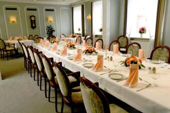 Elegante eetkamer met versierde lange tafel en stoelen in Gasthof Basedau, klaar voor een feestelijke maaltijd.