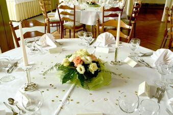 Feestelijk gedekte tafels met kaarsen, bloemstukken en servetten bij Gasthof Basedau voor speciale gelegenheden.