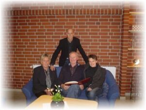 ホテル＆アパルトマンKlostermannのレンガ壁のリビングルームには、ソファとテーブルがあり、4人が座ったり立ったりできる。