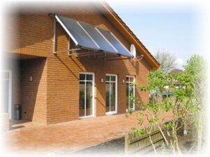 Hotel & Appartements Klostermannの外観。大きな窓、ソーラーパネル、小さな庭がある。